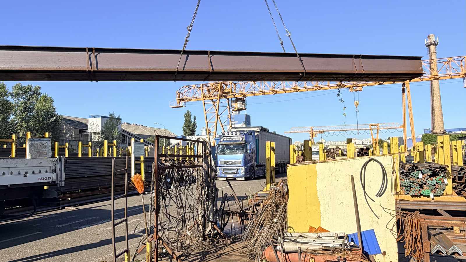 Кран знімає сталеву балку на майданчику Сталіуму