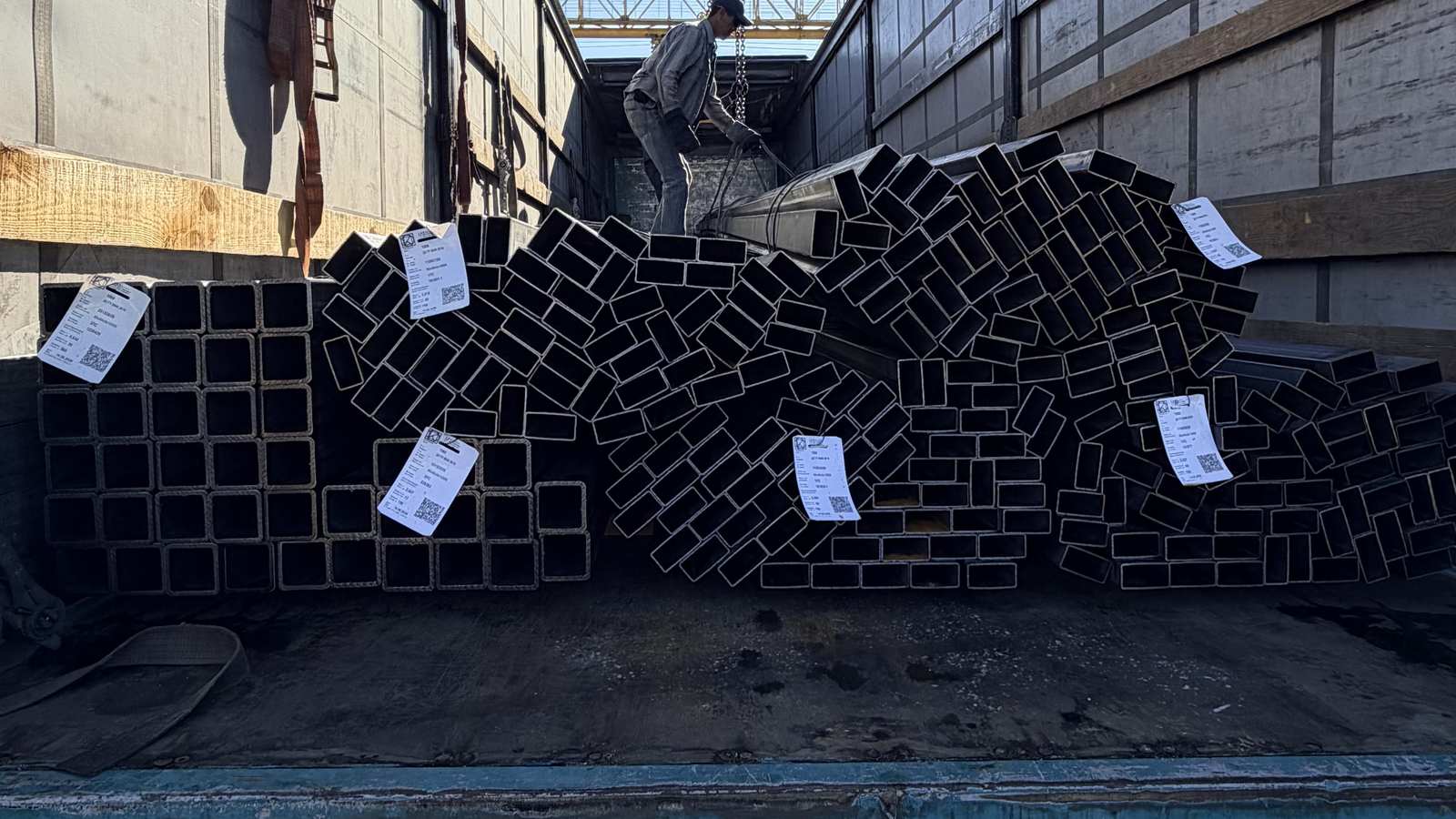 Кран вантажить пачки профільної труби в кузов машини