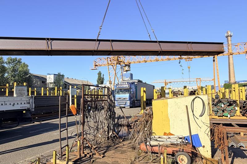 Кран знімає сталеву балку на майданчику Сталіуму